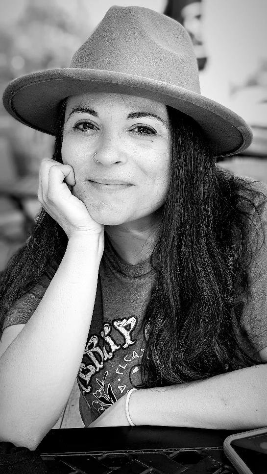 Headshot_SarahDV2 Sarah De Vallière smiling at camera wearing a hat